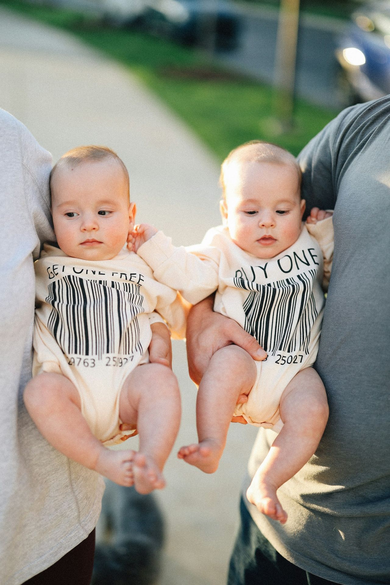 Parents holding adorable twin babies.